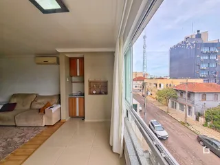 Sala de estar com sofá e grande janela de vista para a rua.