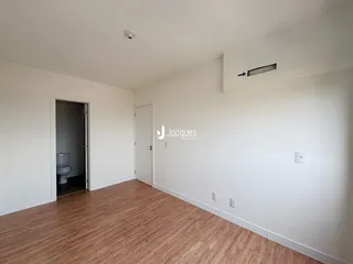 Ambiente interno de uma sala com piso de madeira clara.