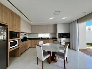 Foto de uma sala de jantar com mesa redonda e armários de madeira na residência.