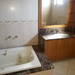 Foto de um banheiro com banheira e bancada de mármore.