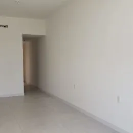Foto de um corredor interno com paredes brancas.