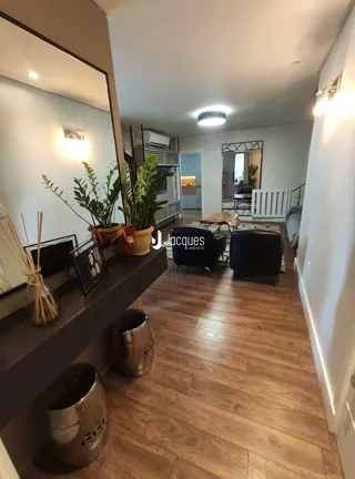 Sala de estar com piso de madeira e decoração de plantas.
