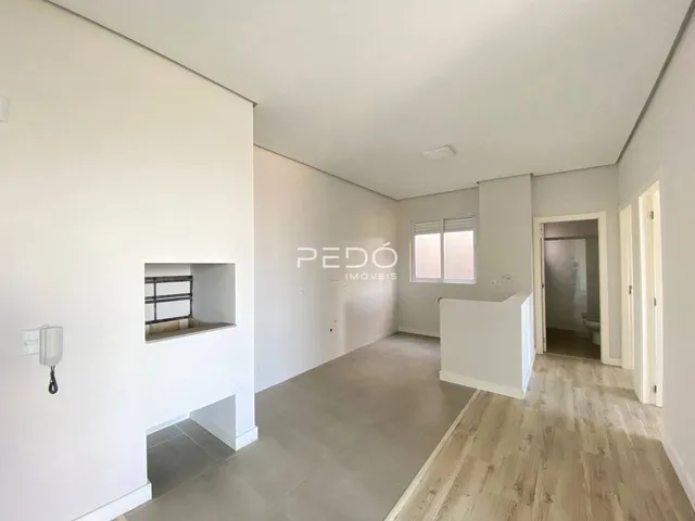Hall de uma propriedade em Lajeado com paredes brancas e piso de madeira clara.