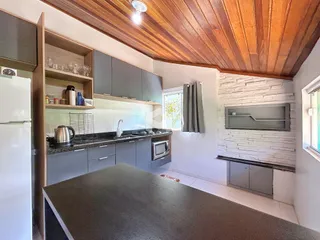 Foto de uma cozinha moderna com teto de madeira e armários cinzas.