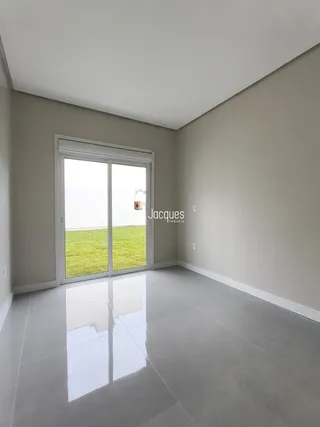 Uma sala com porta de vidro que dá acesso a um gramado verde.
