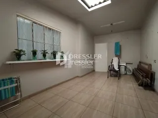 Imagem de um ambiente interno com parede branca e piso de cerâmica.