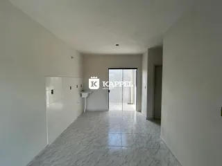 Corredor interno com piso de mármore e armários brancos.
