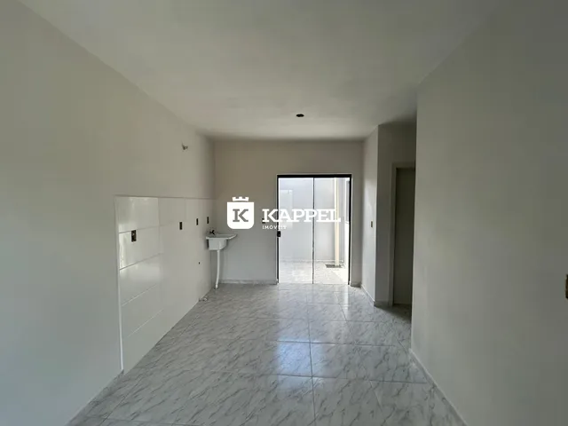 Corredor interno com piso de mármore e armários brancos.