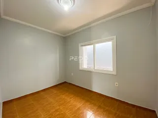 Ambiente interno de uma sala com piso de cerâmica alaranjada.