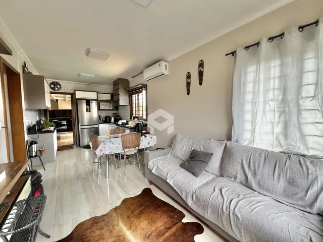 Sala de estar com cozinha aberta e área de jantar em um apartamento.