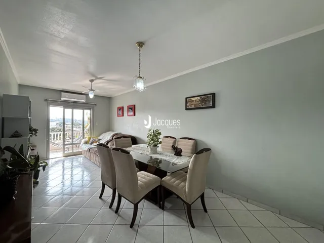Sala de estar com mesa de jantar e vista para o exterior.