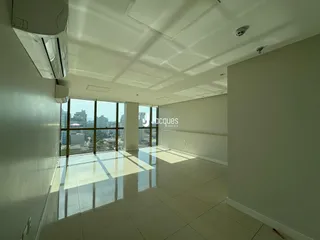 Sala de estar ampla com piso de cerâmica e grandes janelas.