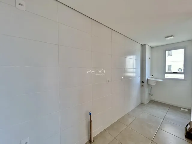 Corredor interno com paredes brancas e piso de cerâmica em um imóvel.