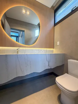 Banheiro moderno com bancada de mármore branco e piso de cerâmica.