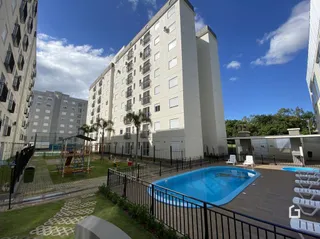 Foto da piscina e área externa de um condomínio residencial.