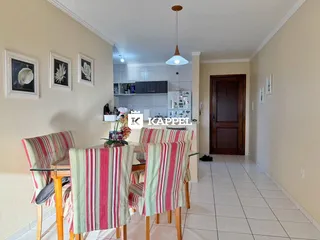 Uma sala de jantar com mesa e cadeiras listradas em um ambiente claro.