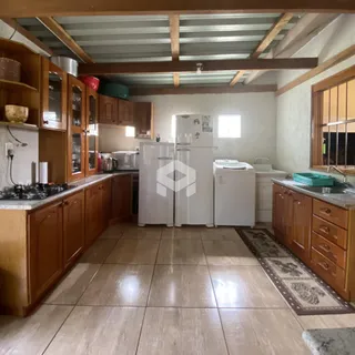 Foto da cozinha com armários de madeira e piso cerâmico.