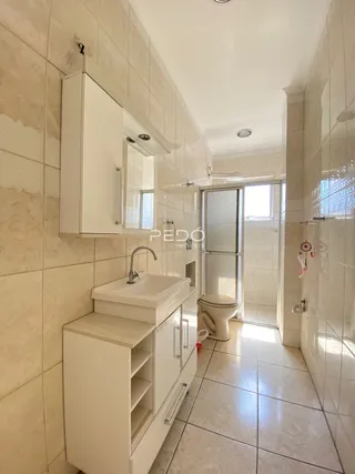 Foto do interior de um banheiro com revestimento de azulejos brancos.