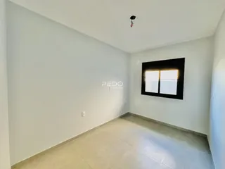 Interior de um ambiente com paredes brancas e piso claro.