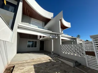 Fachada moderna de uma residência em Lajeado, Brasil, com área externa pavimentada.