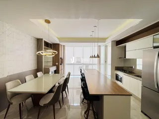 Vista da sala de jantar com mesa de madeira e cadeiras em um apartamento.