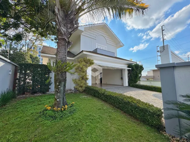Fachada de uma casa em Lajeado, Brasil, com jardim e entrada pavimentada.