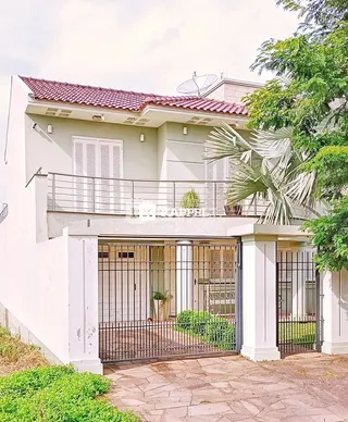 Fachada de uma residência em Lajeado, Brasil, com portão de ferro e área externa.