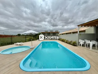 Piscina externa com deck de madeira em uma propriedade.
