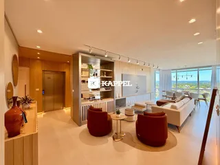 Sala de estar moderna com sofá e poltronas em ambiente iluminado.