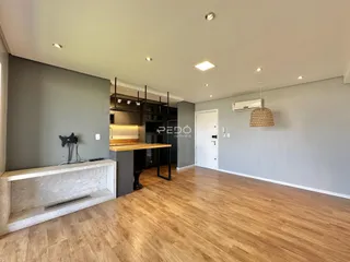 Ambiente moderno com piso de madeira clara e paredes cinzas.