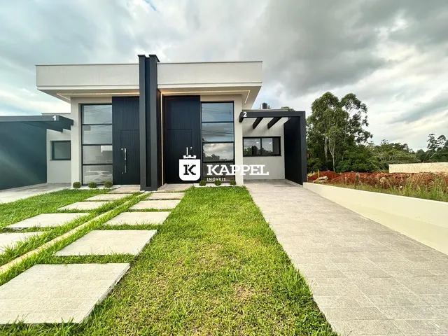 Fachada moderna de uma residência em Lajeado, Brasil, com paisagismo frontal.