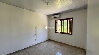 Ambiente interno com parede branca e janela de madeira em Lajeado.