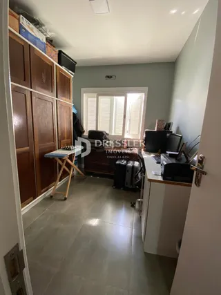 Hall de entrada com armários de madeira e piso claro.