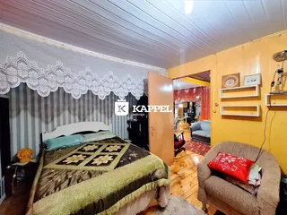 Quarto com cama coberta e parede listrada.