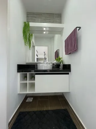 Hall de entrada com espelho e piso de madeira.