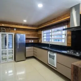 Foto de uma cozinha com armários de madeira e bancada escura.