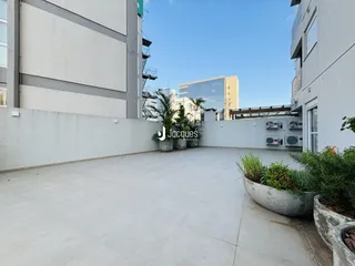 Vista externa de um pátio pavimentado entre dois edifícios residenciais.