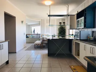 Ambiente moderno de sala de estar com cozinha integrada em Lajeado.