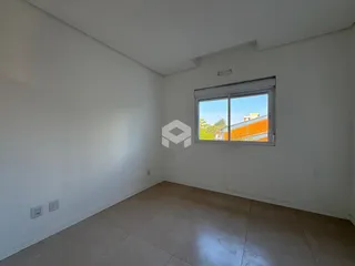 Ambiente interno de uma sala com paredes brancas e piso de cerâmica.