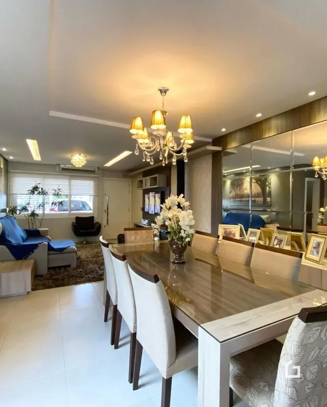 Sala de jantar com mesa de madeira e cadeiras em um imóvel no Brasil.