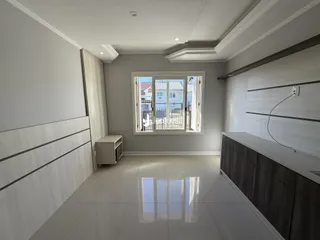 Sala de estar moderna com piso de cerâmica clara.