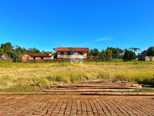 Vista externa de casas em área rural com campo seco.