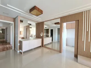 Sala de estar com revestimento de madeira e espelho refletindo o ambiente.