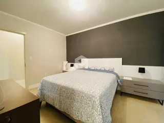 Quarto com cama e parede cinza na residência.
