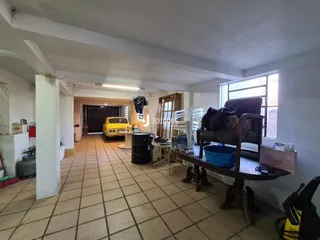 Interior de uma área com piso de cerâmica e parede branca.