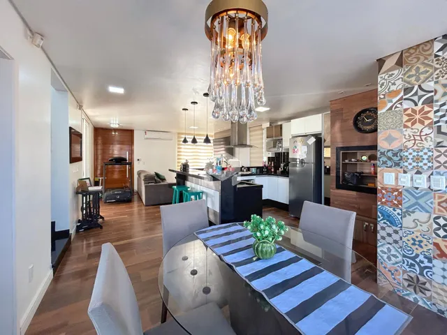 Vista interna de uma sala de jantar com piso de madeira e decoração moderna.