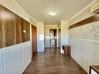 Foto de um corredor interno com piso de madeira e paredes decoradas.