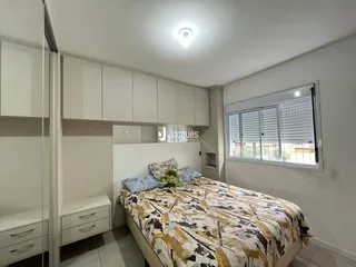 Quarto com armários embutidos e cama decorada.