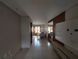 Corredor interno de uma residência com piso de cerâmica clara.