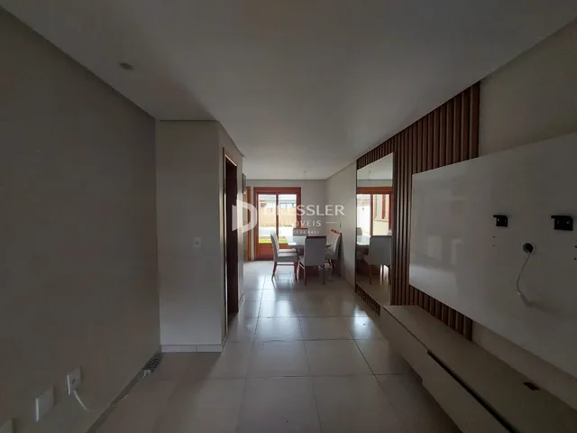 Corredor interno de uma residência com piso de cerâmica clara.